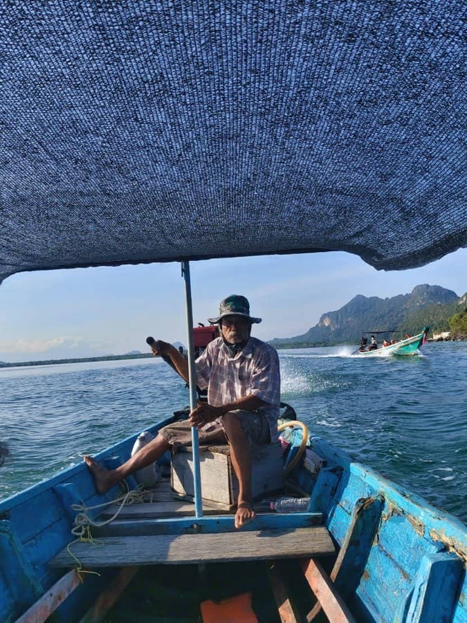 A longtail boatman watching for pink dolphins under the canopy