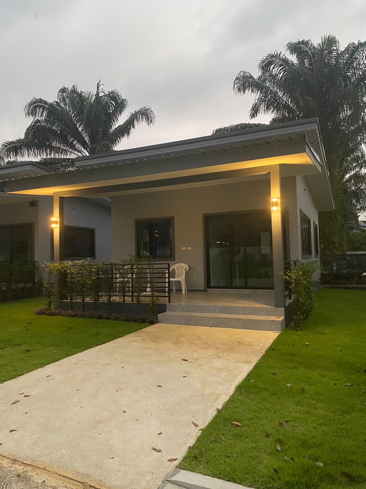 The covered terrace at dusk, warm eave lighting