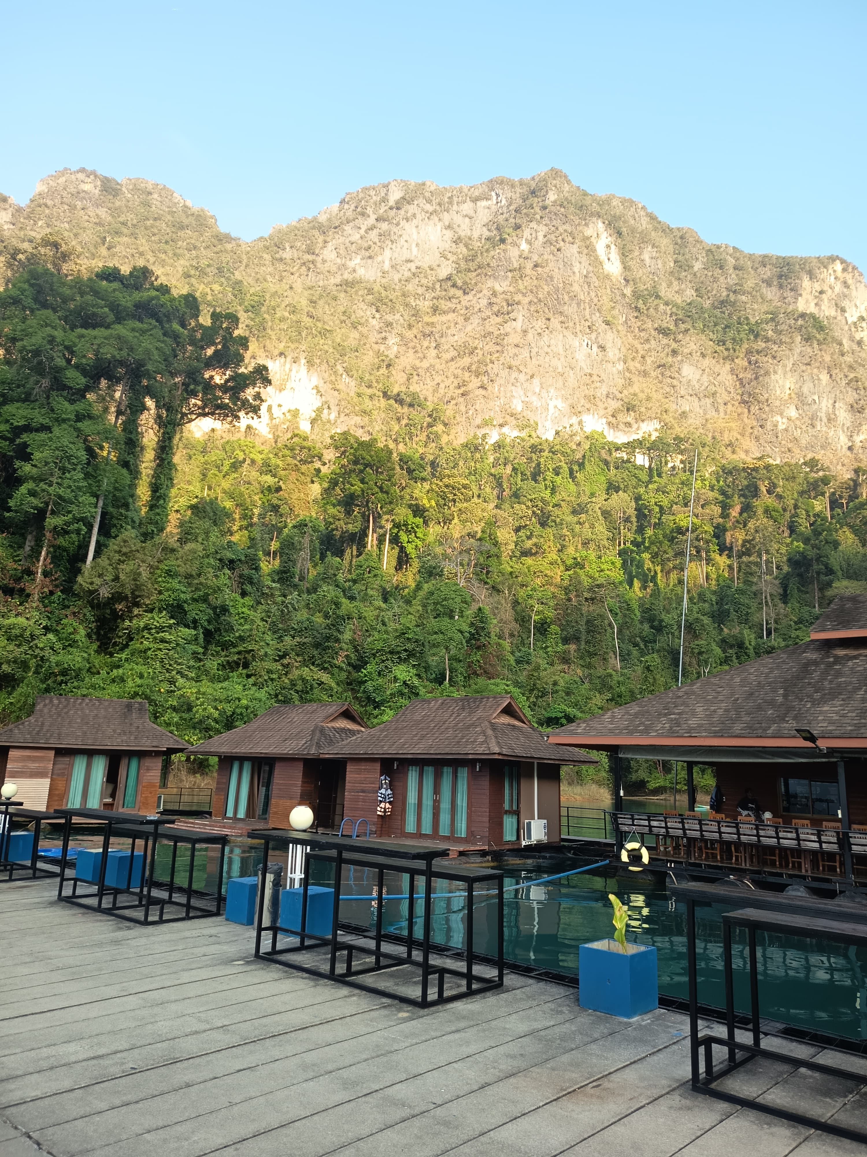 A raft-house deck with railed plunge pools in golden-hour light