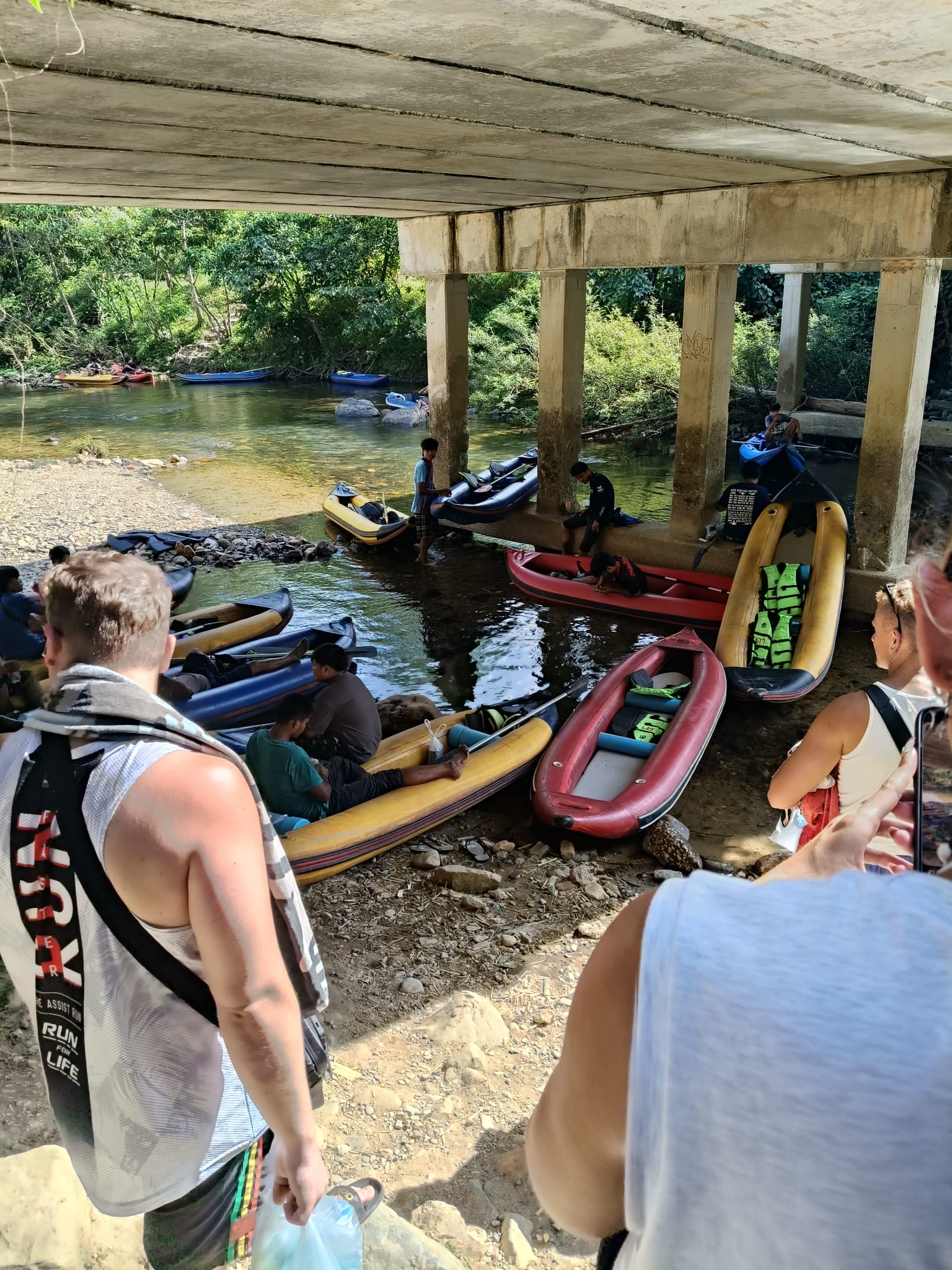 Dozens of kayaks staged under the road bridge at the Sok River put-in